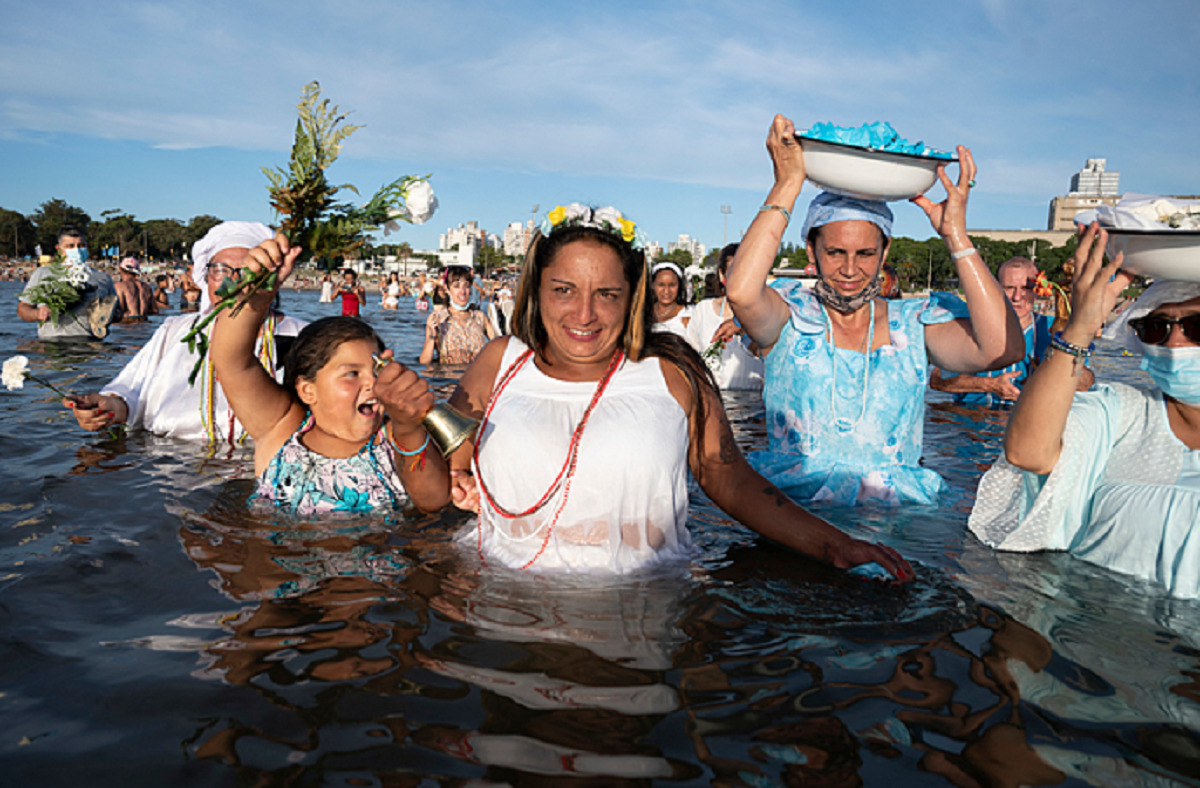Mulheres fazem oferenda a Iemanjá na praia de Ramirez, no Uruguai, em fevereiro deste ano. - Pablo Porciuncula/AFP