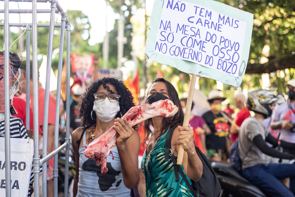Com osso bovino nas mãos simbolizando a fome, mulher protesta contra o presidente Jair Bolsonaro (PL) | Foto: Thales Antonio/Shutterstock