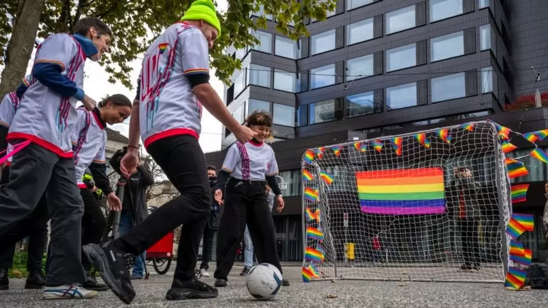 Ativistas jogam futebol durante uma ação simbólica de associações LGBTQIA+ em frente ao museu da FIFA em Zurique, em novembro de 2022 | Foto: Fabrice Coffrini/AFP via Getty Images