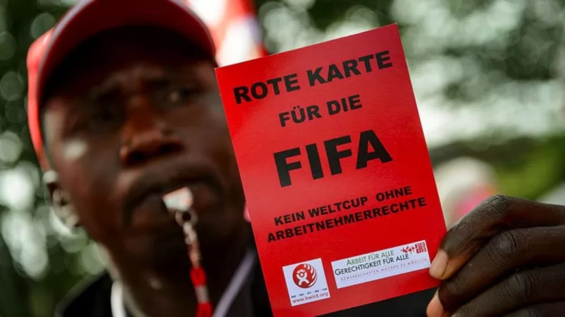 Manifestante dá "cartão vermelho" para a Fifa | Foto: Reprodução/BBC.com