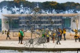 Bolsonatistas radicais são vistos por meio de janela vandalizada do Palácio do Planalto | Foto: Adriano Machado/Reuters